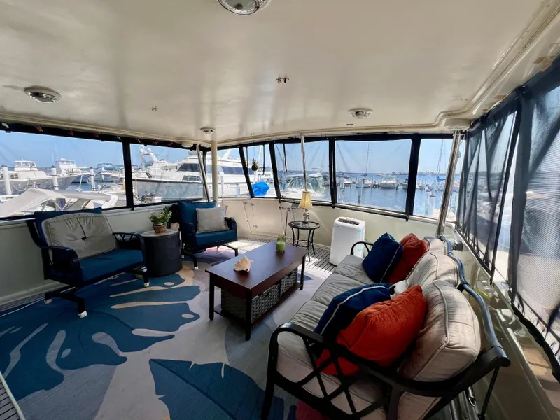 Slide: The Image of Spacious interior of 1989 Californian 48MY yacht with marina view, featuring cozy seating and decor. - 19