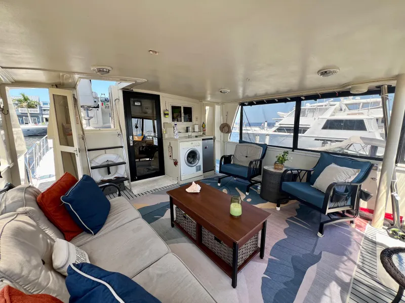 Slide: The Image of Spacious 1989 Californian 48MY yacht interior with cozy seating, washing machine, and large windows. - 20