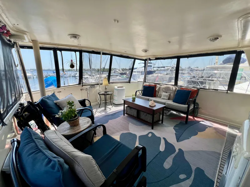 Slide: The Image of Spacious interior of 1989 Californian 48MY yacht with comfortable seating and marina view. - 22