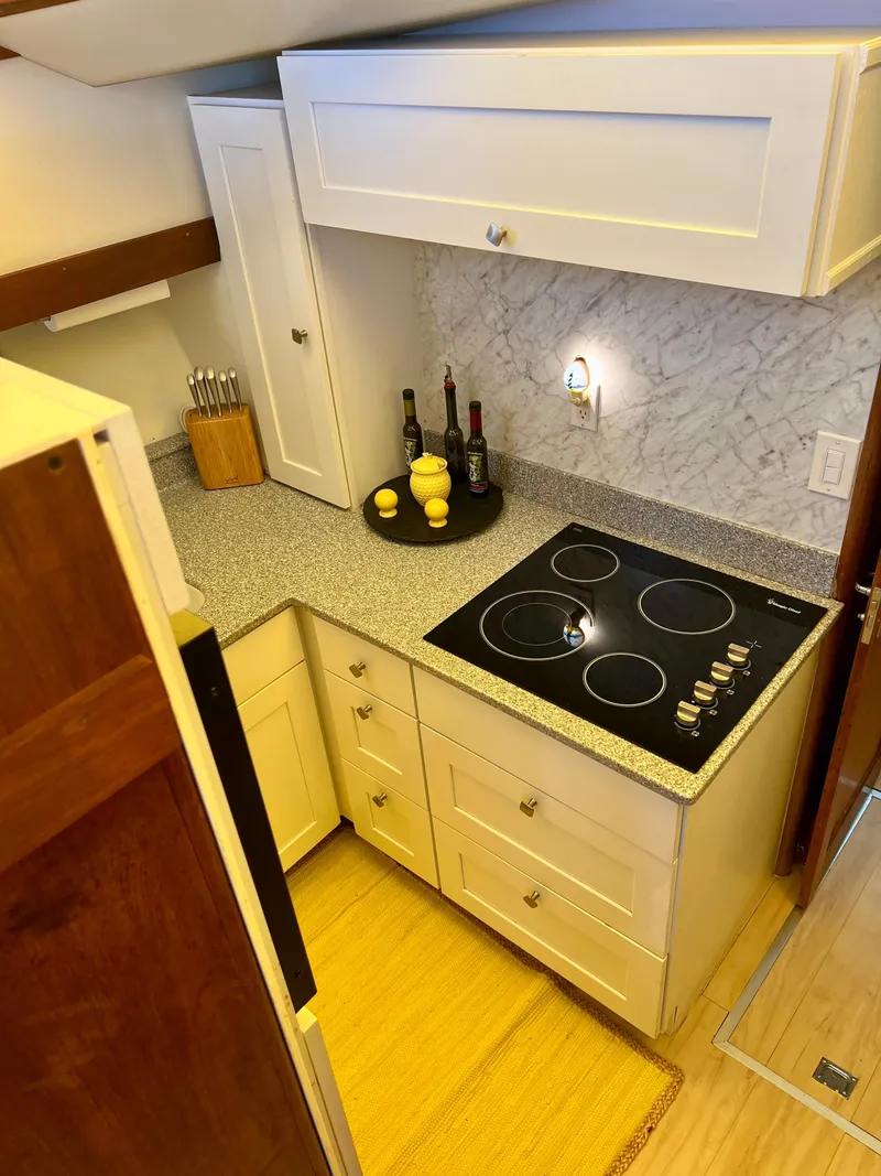 Slide: The Image of Compact kitchen in a 1989 Californian 48MY yacht with modern appliances and marble backsplash. - 42