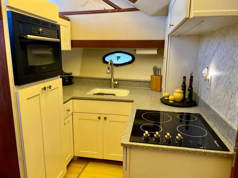 Slide: The Image of Compact kitchen in a 1989 Californian 48MY yacht with modern appliances and sleek countertops. - 43