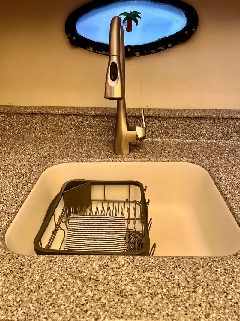 Slide: The Image of Modern kitchen sink with a sleek faucet and dish rack, granite countertop, and decorative window. - 46