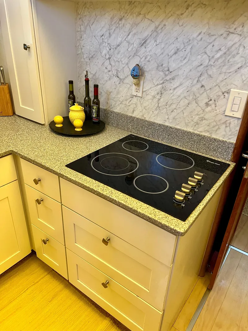 Slide: The Image of Modern kitchen with electric cooktop, marble backsplash, and decorative bottles on a 1989 Californian 48MY. - 47