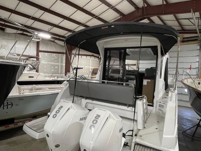 Slide: The Image of 2022 Beneteau Antares 9 boat with twin Mercury engines in a storage facility. - 14