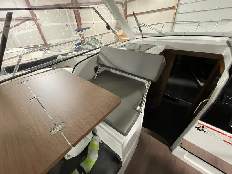 Slide: The Image of Interior of 2022 Beneteau Antares 9 boat with seating and wooden table. - 22
