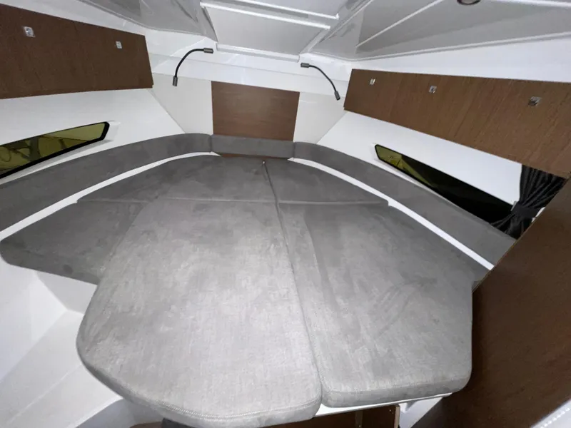 Slide: The Image of Interior cabin of 2022 Beneteau Antares 9 with gray cushions and wood accents. - 27