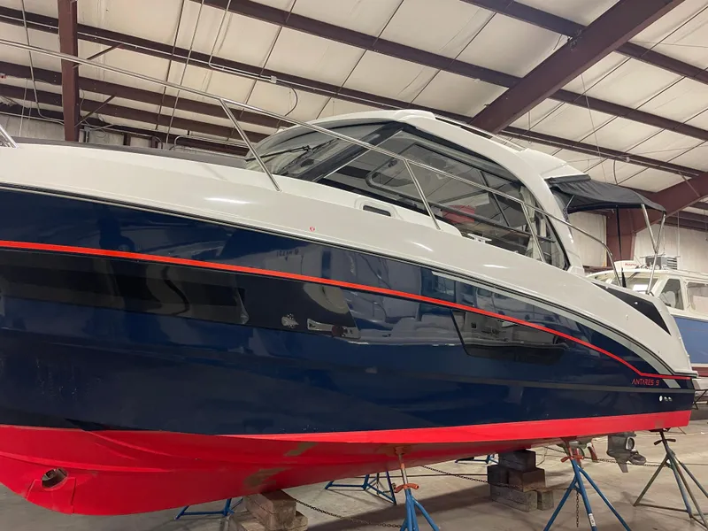 Slide: The Image of 2022 Beneteau Antares 9 boat in a warehouse, featuring a sleek blue and red design. - 6