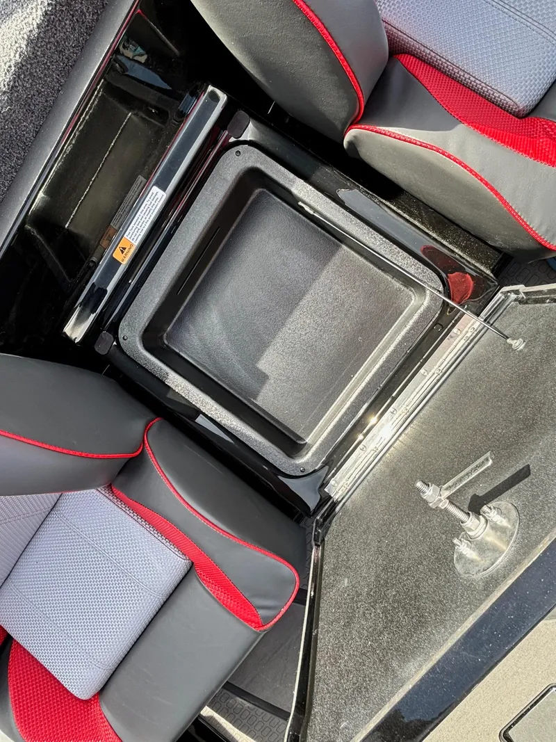 Slide: The Image of 2025 Triton 20XP Patriot boat interior with storage compartment and seating. - 10