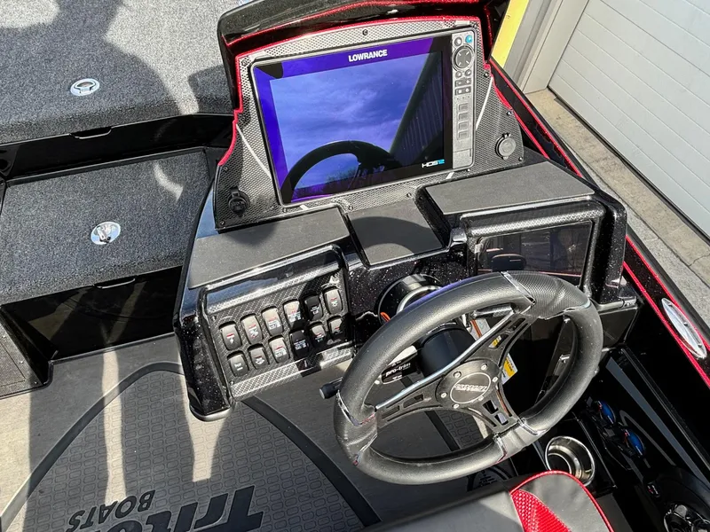 Slide: The Image of 2025 Triton 20XP Patriot boat dashboard with steering wheel and navigation display. - 11