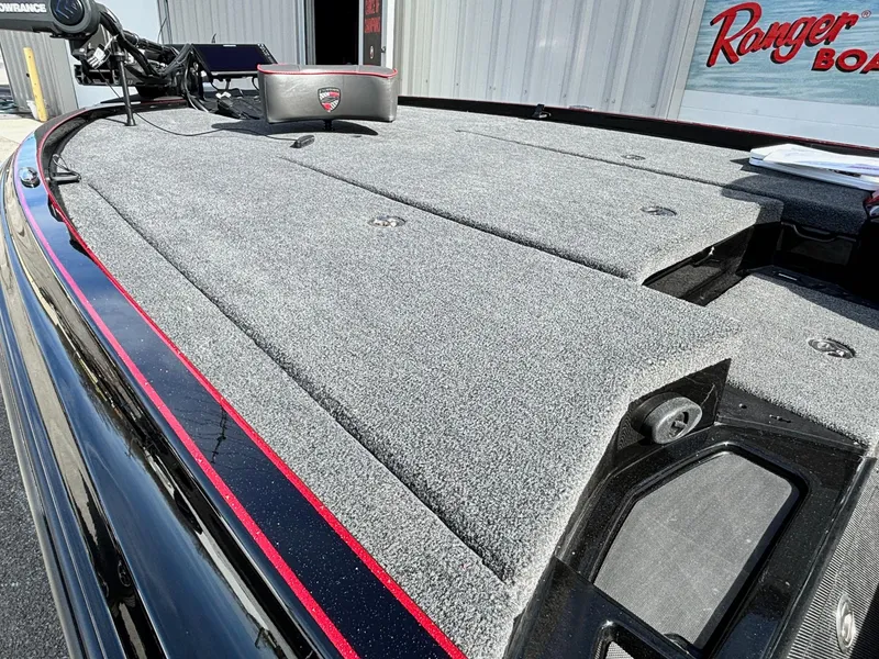 Slide: The Image of 2025 Triton 20XP Patriot boat deck with gray carpet and red trim. - 4