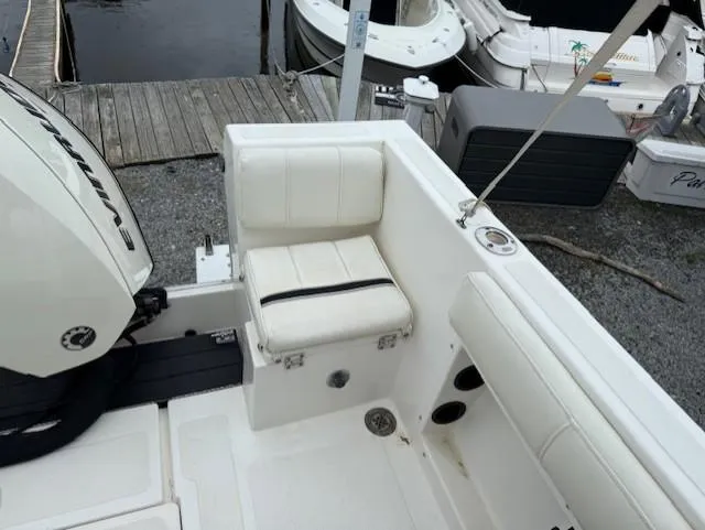 Slide: The Image of 1994 Hydra-Sports 2000 CC boat interior with white seating and motor, docked by the water. - 10