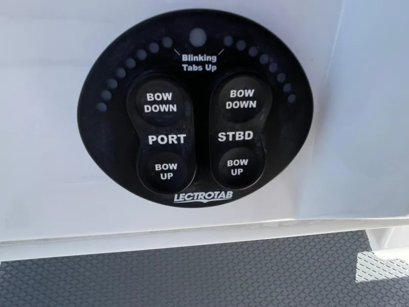 Slide: The Image of Control panel for trim tabs on a 2014 Southport 27 Center Console boat. - 11