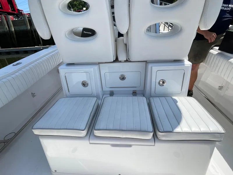 Slide: The Image of 2014 Southport 27 Center Console boat with white cushioned seating and storage compartments. - 18