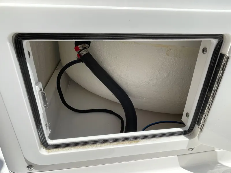 Slide: The Image of Storage compartment of 2014 Southport 27 Center Console boat with visible hose. - 21