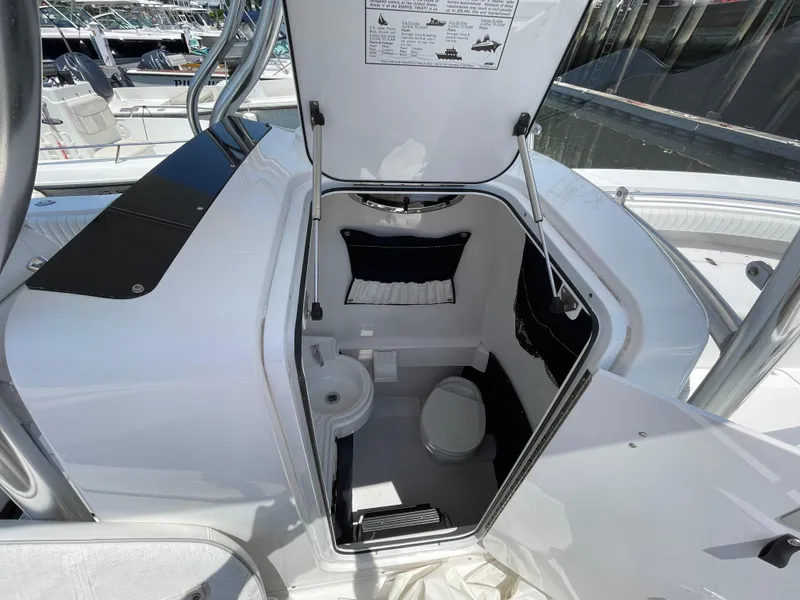 Slide: The Image of 2014 Southport 27 Center Console boat interior with open hatch and compact restroom. - 26