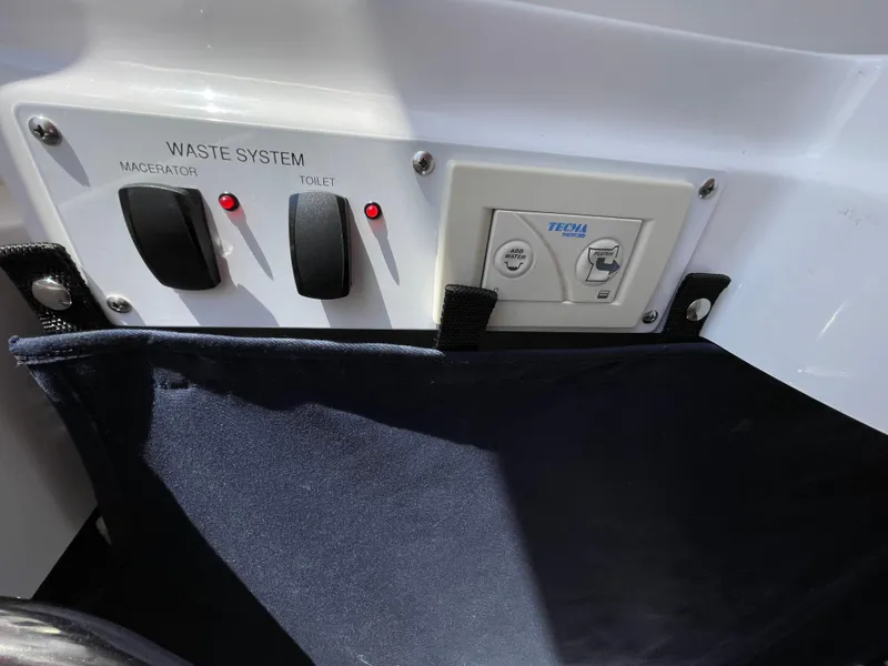 Slide: The Image of Control panel of 2014 Southport 27 Center Console waste system with switches and indicators. - 27