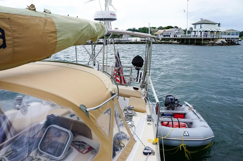 Slide: The Image of 2001 J Boats J/42 sailboat docked with dinghy, coastal background. - 15
