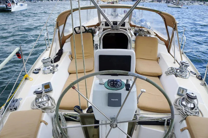 Slide: The Image of 2001 J Boats J/42 sailboat cockpit with tan cushions and navigation equipment. - 17
