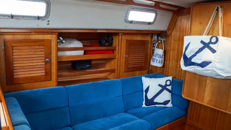Slide: The Image of Interior of 2001 J Boats J/42 with blue seating, anchor-themed decor, and wooden cabinetry. - 22