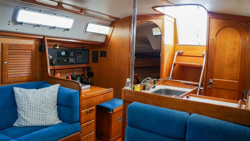 Slide: The Image of Interior of 2001 J Boats J/42 sailboat with blue seating and wooden cabinetry. - 23