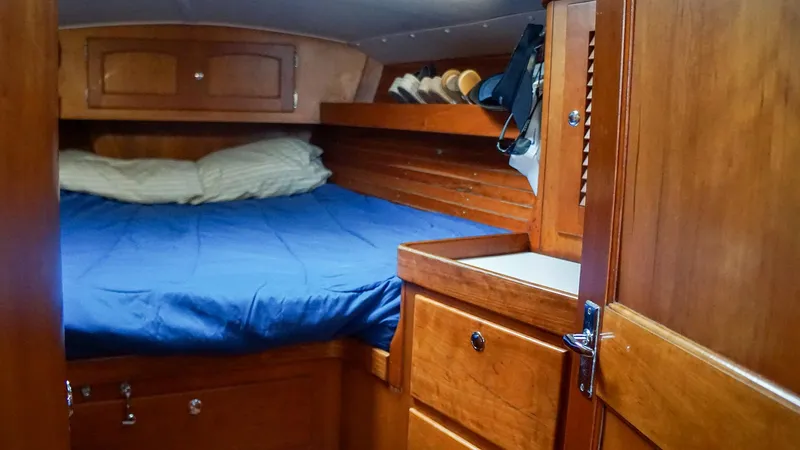 Slide: The Image of 2001 J Boats J/42 cabin interior with wooden cabinetry and blue bedding. - 24