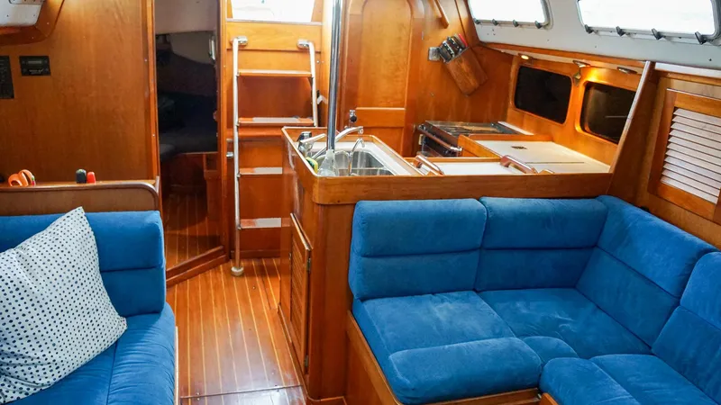 Slide: The Image of Interior of 2001 J Boats J/42 yacht with blue seating and wooden finishes. - 26