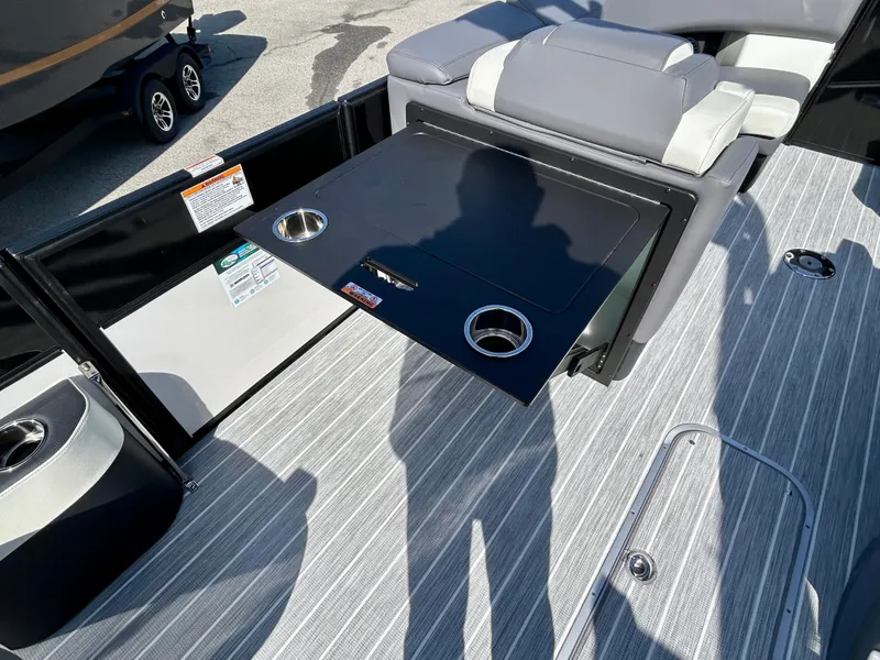 Slide: The Image of 2025 Berkshire 23UL STS 3.0 boat interior with foldable table and cup holders. - 16