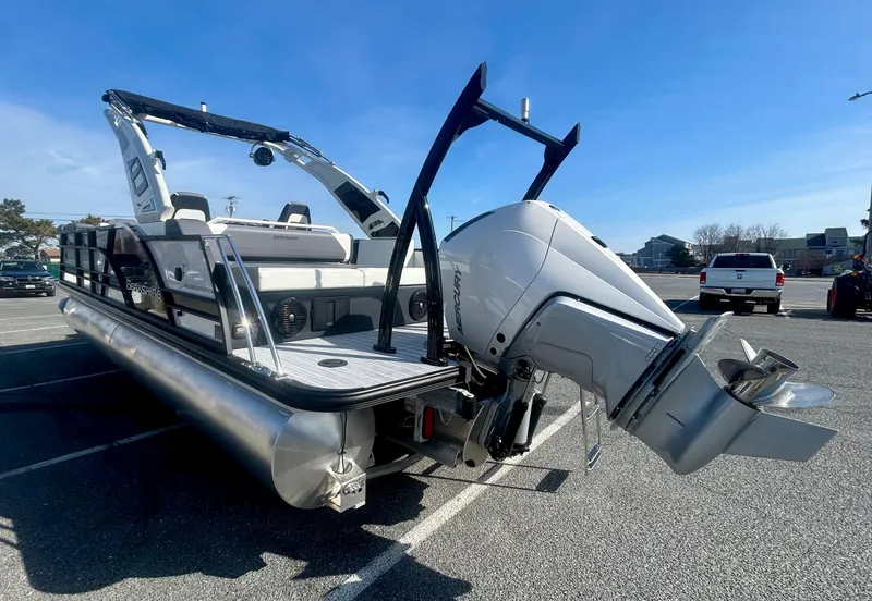 Slide: The Image of 2025 Berkshire 23UL STS 3.0 pontoon boat with powerful outboard motor in parking lot. - 19