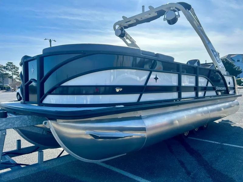 Slide: The Image of 2025 Berkshire 23UL STS 3.0 pontoon boat on trailer, sleek design, sunny day. - 2