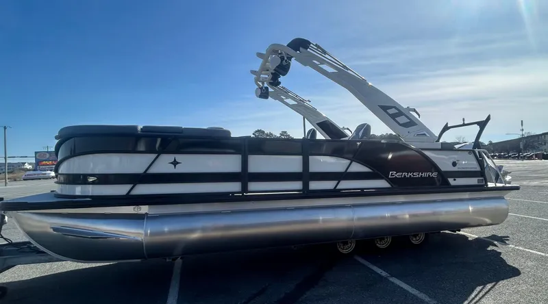 Slide: The Image of 2025 Berkshire 23UL STS 3.0 pontoon boat parked in a lot under clear skies. - 4