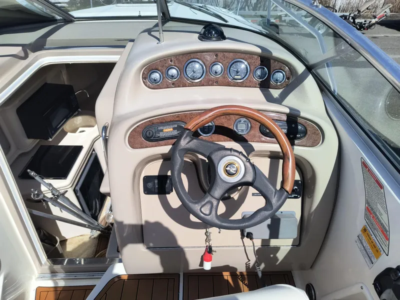 Slide: The Image of 2001 Sea Ray 260 Sundancer boat dashboard with wood accents and steering wheel. - 10