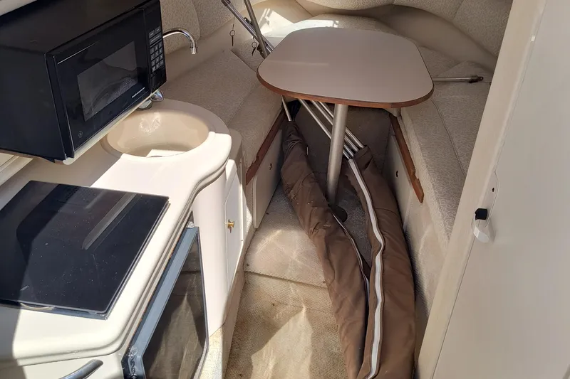 Slide: The Image of Interior of 2001 Sea Ray 260 Sundancer with kitchenette and seating area. - 12