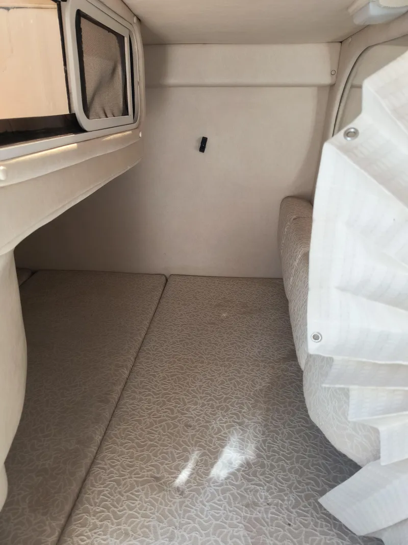 Slide: The Image of 2001 Sea Ray 260 Sundancer cabin interior with beige upholstery and compact design. - 14