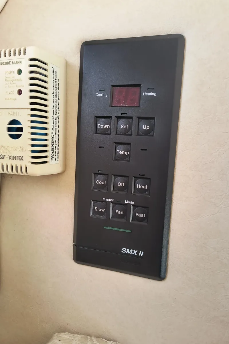 Slide: The Image of Control panel on 2001 Sea Ray 260 Sundancer boat, featuring temperature and fan settings. - 17