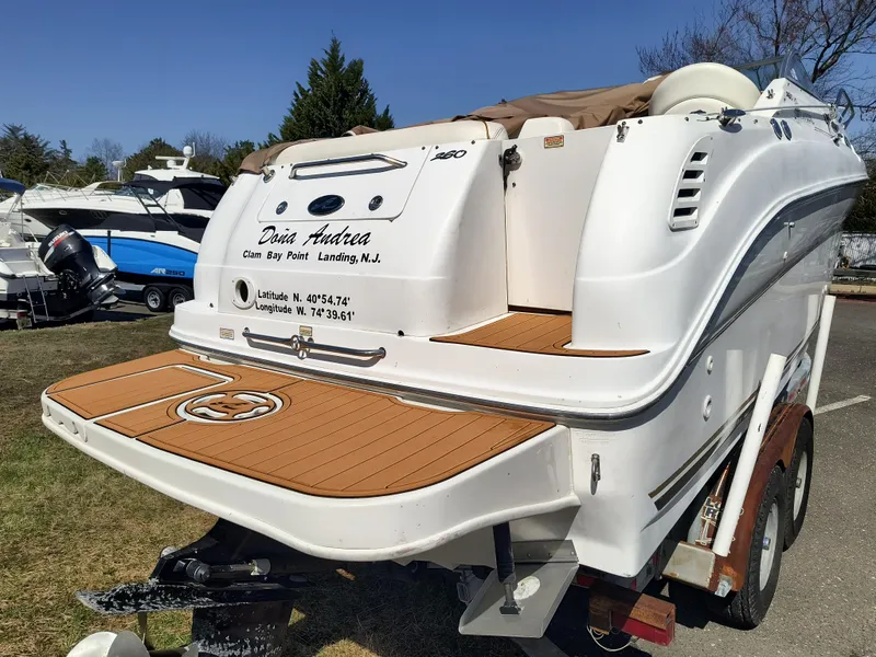 Slide: The Image of 2001 Sea Ray 260 Sundancer boat on trailer, featuring teak swim platform. - 3