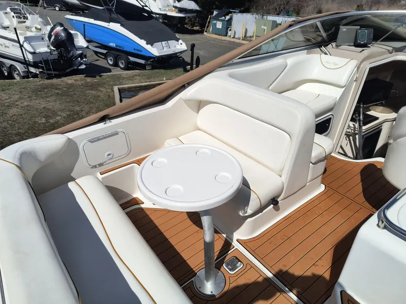 Slide: The Image of 2001 Sea Ray 260 Sundancer boat interior with white seating and round table. - 5