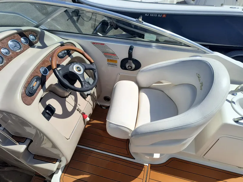 Slide: The Image of 2001 Sea Ray 260 Sundancer boat cockpit with steering wheel and comfortable seating. - 9