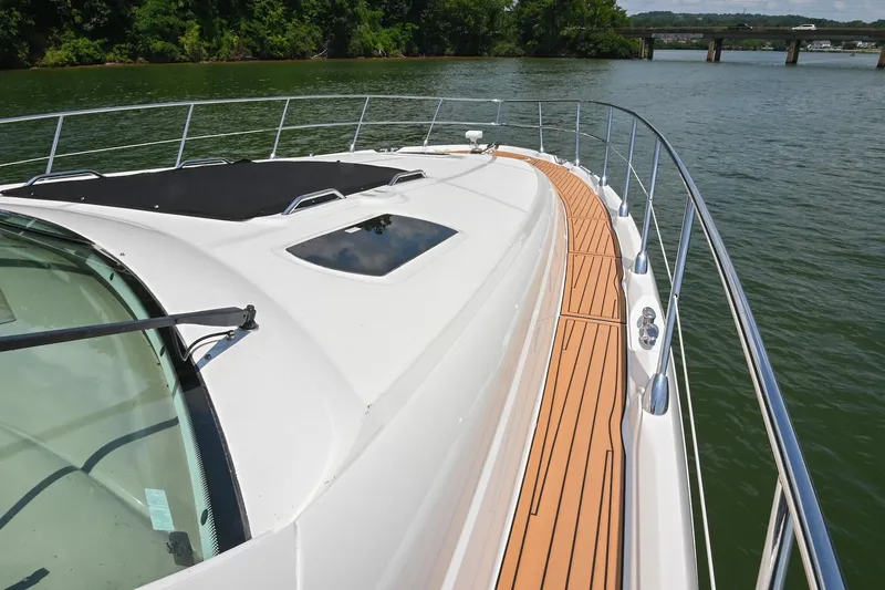 Slide: The Image of 2007 Sea Ray 60 Sundancer yacht deck with sleek design on calm water. - 22
