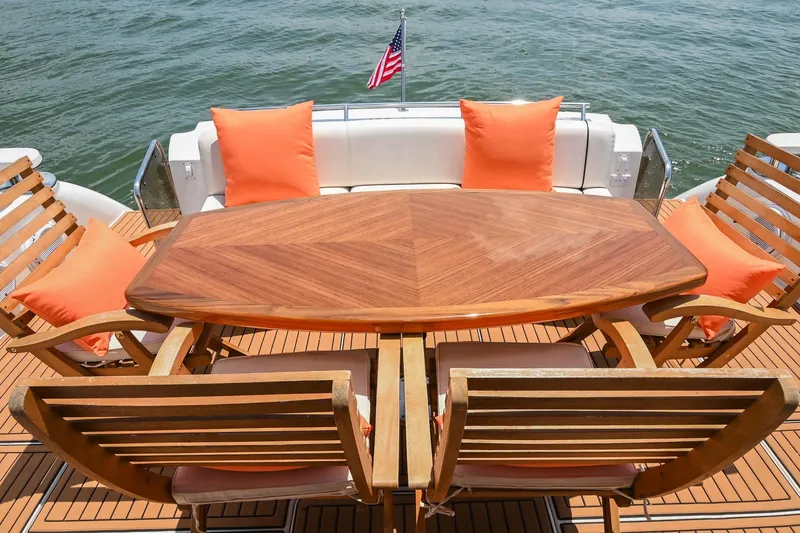 Slide: The Image of Luxury yacht deck with wooden table, orange cushions, and water view on a 2007 Sea Ray 60 Sundancer. - 31