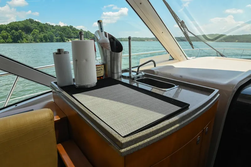 Slide: The Image of Luxurious 2007 Sea Ray 60 Sundancer yacht interior with kitchenette and scenic lake view. - 48