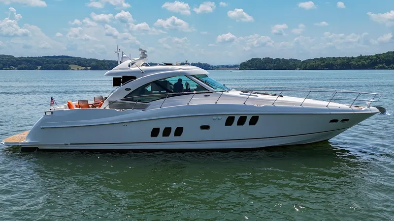 Slide: The Image of 2007 Sea Ray 60 Sundancer yacht cruising on a serene lake under a blue sky. - 6