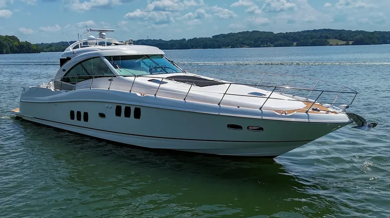 Slide: The Image of 2007 Sea Ray 60 Sundancer yacht cruising on a serene lake under a clear sky. - 7