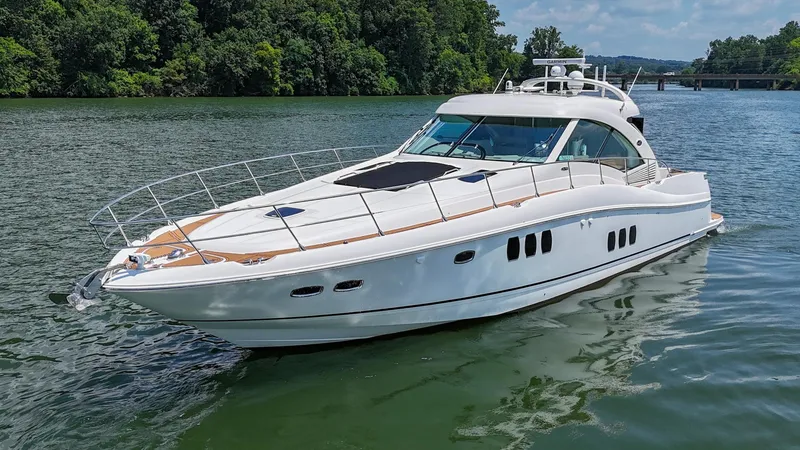 Slide: The Image of 2007 Sea Ray 60 Sundancer yacht cruising on a serene lake with lush green surroundings. - 9