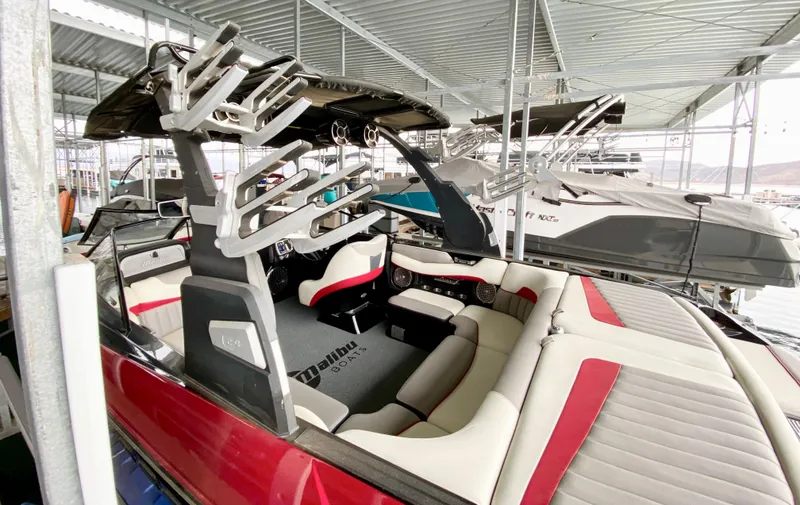 Slide: The Image of 2015 Malibu Wakesetter 22 MXZ boat with red and white interior, docked in a marina. - 11