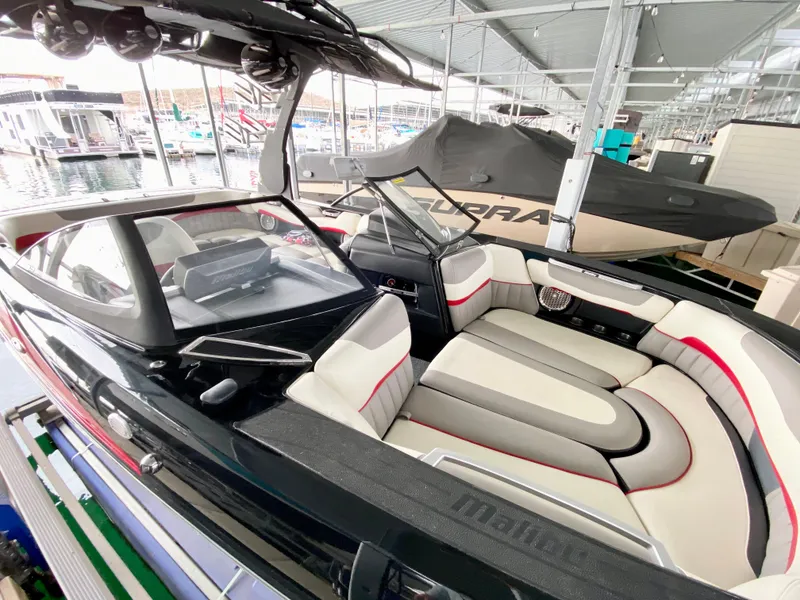 Slide: The Image of 2015 Malibu Wakesetter 22 MXZ interior with sleek seating in a marina setting. - 12