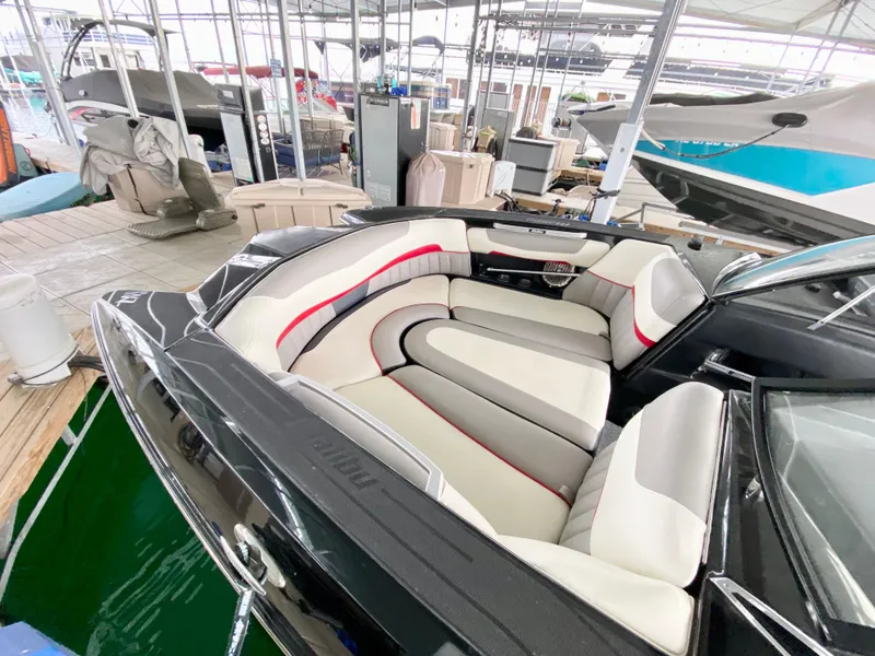 Slide: The Image of 2015 Malibu Wakesetter 22 MXZ interior with plush seating in a marina setting. - 13