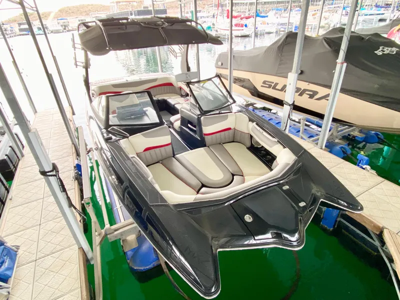 Slide: The Image of 2015 Malibu Wakesetter 22 MXZ boat docked, featuring sleek design and spacious seating. - 8