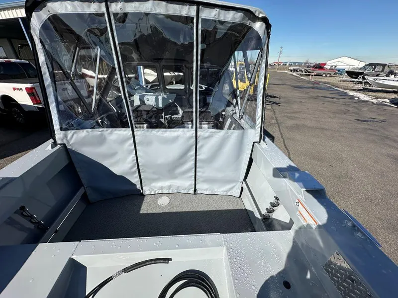 Slide: The Image of 2025 Hewescraft 160 Sportsman boat with covered cockpit, parked outdoors. - 4