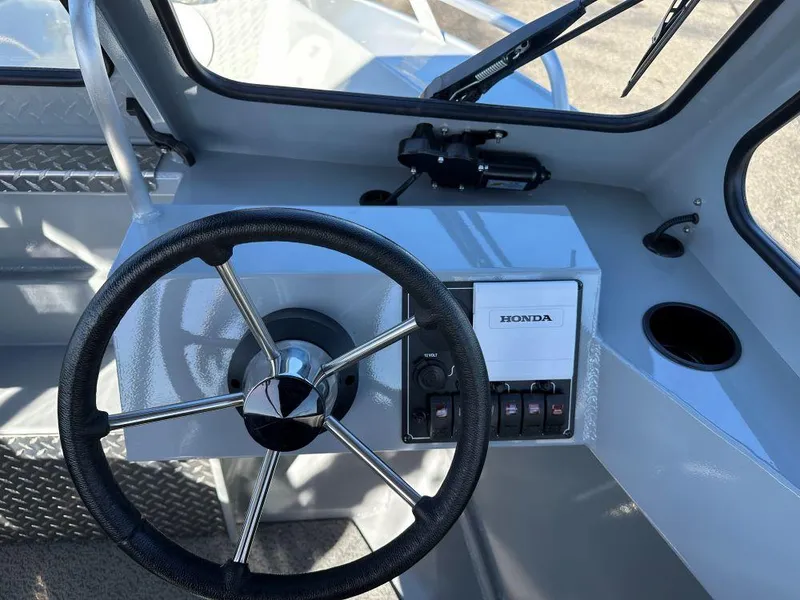 Slide: The Image of 2025 Hewescraft 160 Sportsman boat dashboard with steering wheel and Honda controls. - 6