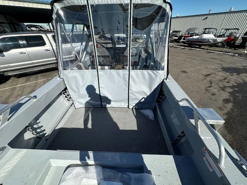 Slide: The Image of 2025 Hewescraft 180 Sportsman boat with covered cabin, parked outdoors. - 4